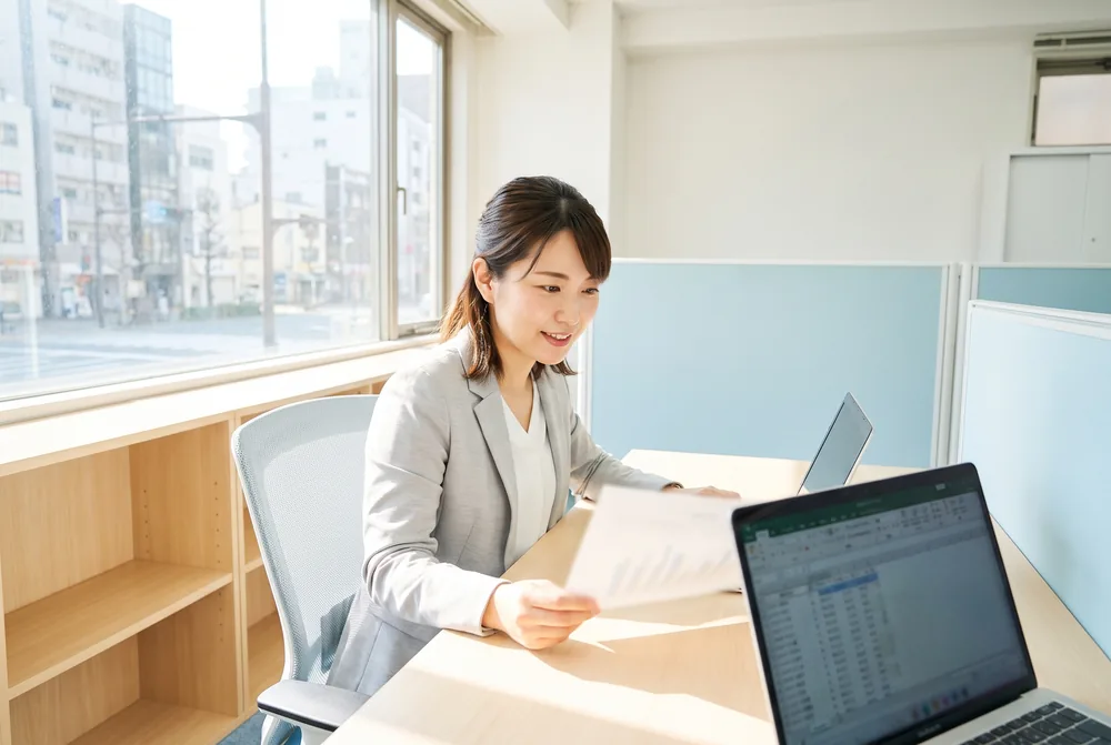 書類とパソコンで採用業務を進めるスタッフ